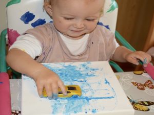 Kleinkinder und Babys bemalen eine Leinwand mit Spielzeugautos | von Fantasiewerk